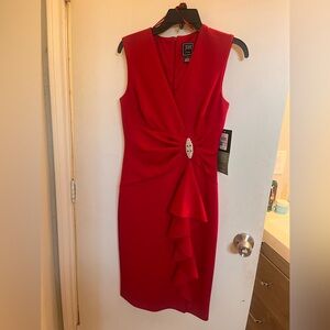 Red burgundy dress goes down to the knees. Sleeveless.